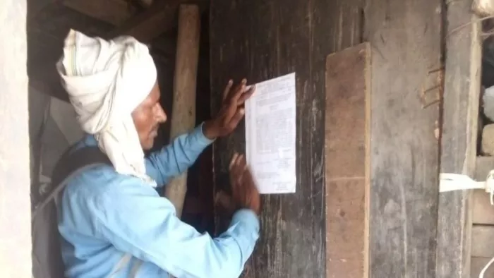 कल्याणपुर में अवैध कब्जेदार के घर में नोटिस चस्पा करता कर्मचारी। पीडब्ल्यूडी एनएच