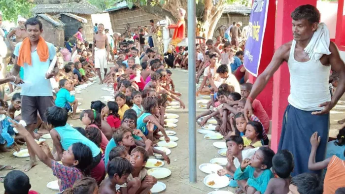 राघोपुर में बाढ़ प्रभावित बच्चों को खाना खिलाते लोग