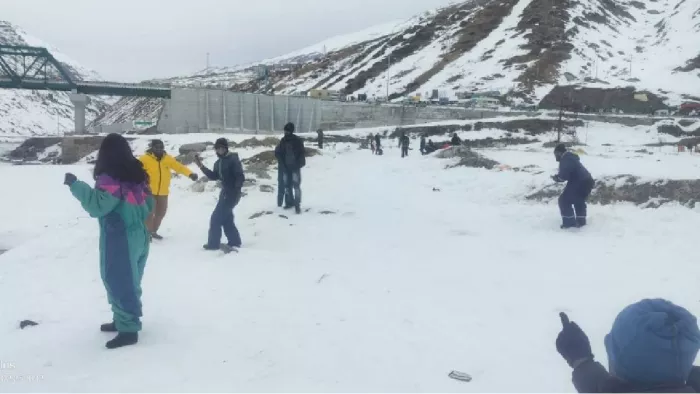 अटल टनल रोहतांग के नॉर्थ पोर्टल में मंगलवार को बर्फ के फाहों का आनंद लेते पर्यटक