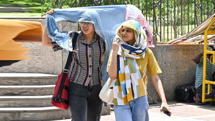 चिलचिलाती धूप से बचने के लिए महिलाएं अपने सिर पर स्कार्फ लपेटती हुई। (फोटो- एएनआई)