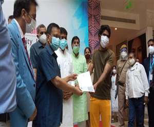 टीकाकरण करा चुके नीरज को सर्टिफिकेट प्रदान करते मुख्यमंत्री अरविंद केजरीवाल।