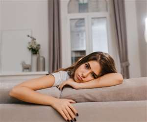 सोफे पर थक कर लेटी हुई युवती