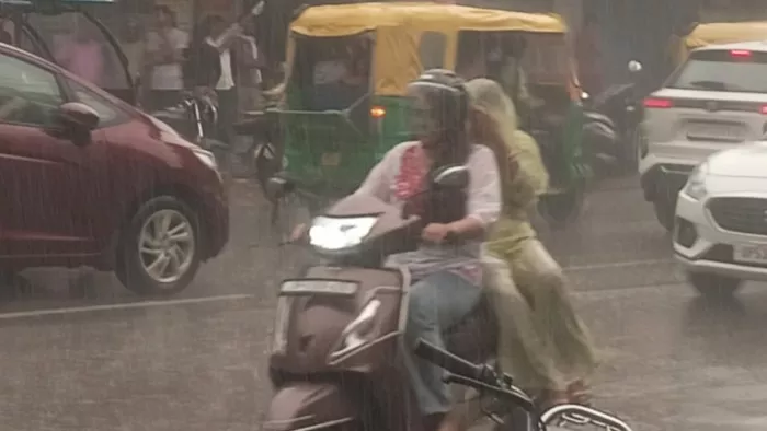 मानसून की बारिश में आते-जाते लोग। जागरण