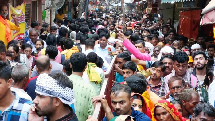 रेलिंग से निकलते आने और जाने वाले श्रद्धालु।