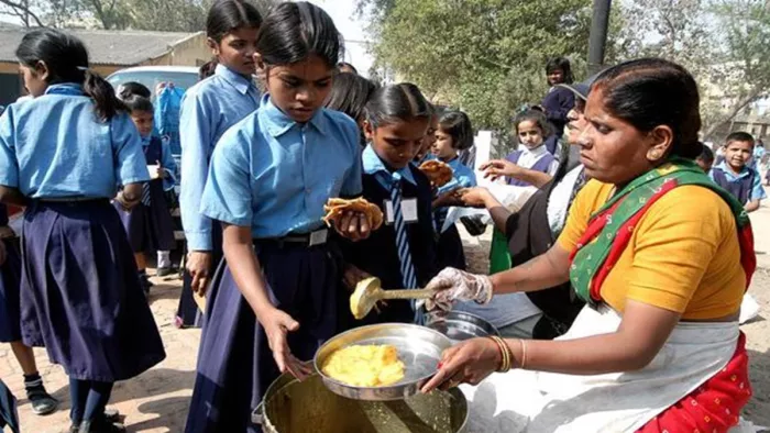 सरकारी स्कूल में बच्चों को खाना खिलातीं रसोइया (जागरण)