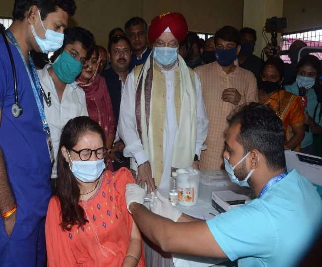 महिला को टीका लगाने के दौरा पास में खड़े केंद्रीय शहरी विकास मंत्री हरदीप सिंह पुरी।