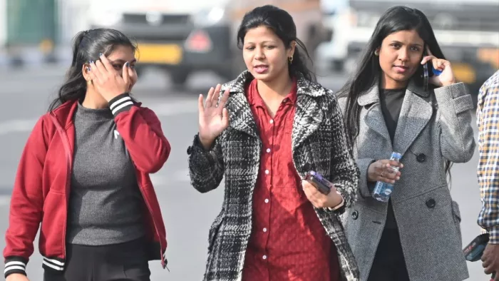 आईटीओ चौराहे के समीप तेज से बचाव के लिए रविवार को चेहरे पर हाथ रखकर जाती युवतियां। फोटो- जागरण