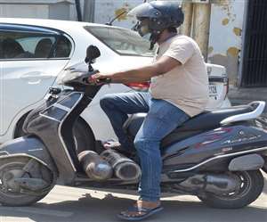 कानपुर में स्कूटी से सिलिंडर लेकर जाता हुआ युवक।