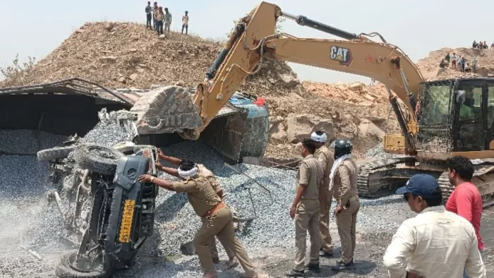 गिट्टी के मलबे में दबे हुए एंबुलेंस को बाहर जेसीबी की मदद से बाहर निकालने का प्रयास करती पुलिस। जागरण