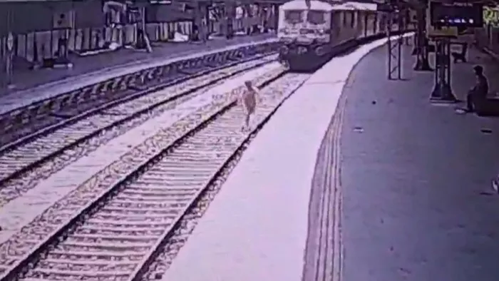 स्टेशन पर हुए झगड़े के बाद रेल ट्रैक पर खड़ी महिला की तस्वीर। सीसीटीवी से ली पिक्चर।