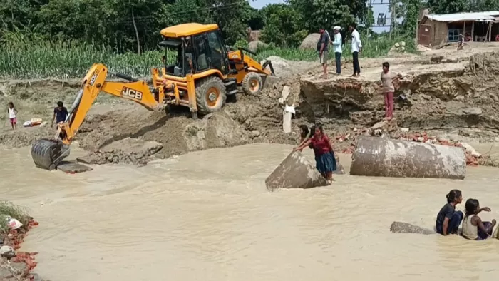ध्वस्त पुल को ठीक कर फिर से आवागमन चालू कराने में जुटी मशीन।