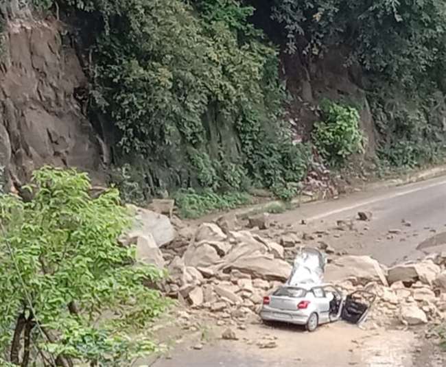 नूरपुर में नेशनल हाइवे पर सड़क किनारे भारी भरकम चट्टान खिसक कर कार पर गिर गई।