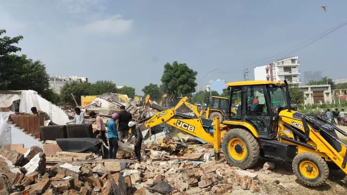 ग्रेटर नोएडा वेस्ट मेें ग्रीन बेल्ट में बनी अवैध दुकानों को ध्वस्त करता बुलडोजर । सौ. प्राधिकरण