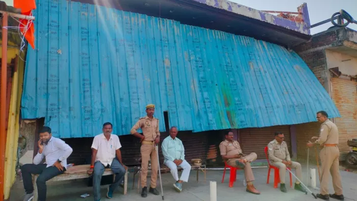 महराज गंज हिंसा के आरोपित कर घर के बाहर मौजूद पुलिस कर्मी . जागरण