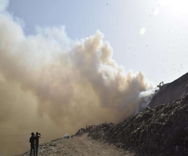 ग़ाज़ीपुर लैंडफिल साइट में लगी आग को बुझाते दमकलकर्मी। फोटो- पारस कुमार