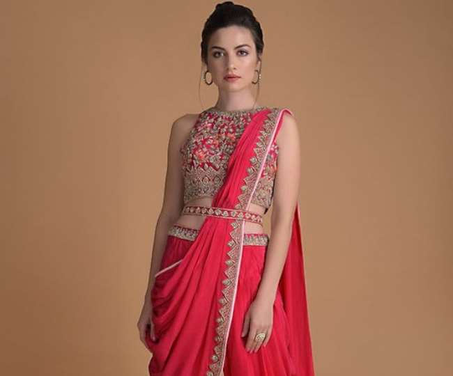 रेड साड़ी को डिफरेंट स्टाइल से कैरी की हुई युवती