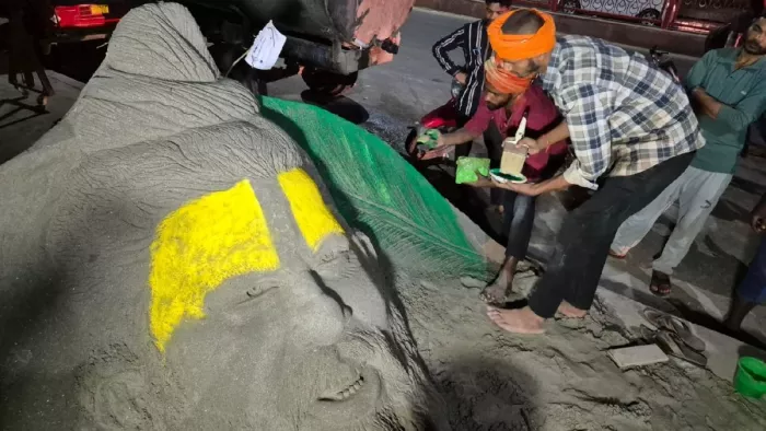वृंदावन में संत प्रेमानंद की बालू से आकृति बनाते बलिया से आए सेंड आर्टिस्ट रूपेश सिंह व उनके सहयोगी।