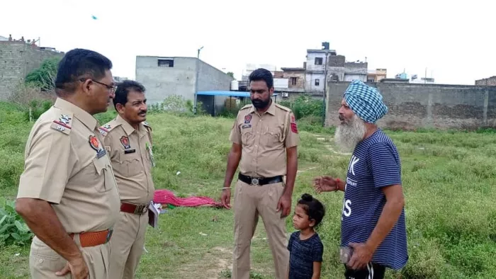 मुंडिया कला इलाके के प्लाट में वृद्ध का शव मिलने के बाद उसके बेटे से पूछताछ करती पुलिस। (जागरण)