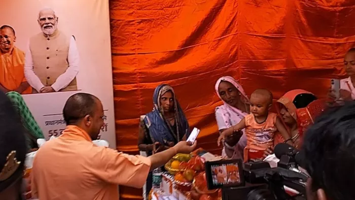 Kasganj News: बरौना गांव पहुंचकर बच्चे को चाकलेट देते सीएम योगी आदित्यनाथ।