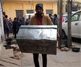 नकदी को रखने के लिए बक्से को ले जाता कर्मचारी।