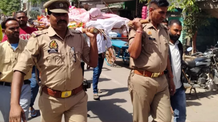 Agra News: महिला की मृत्यु के बाद शव को कंधा देते इंस्पेक्टर आनंदवीर दाएं और दारोगा संदीप राठी। सौ. पुलिस