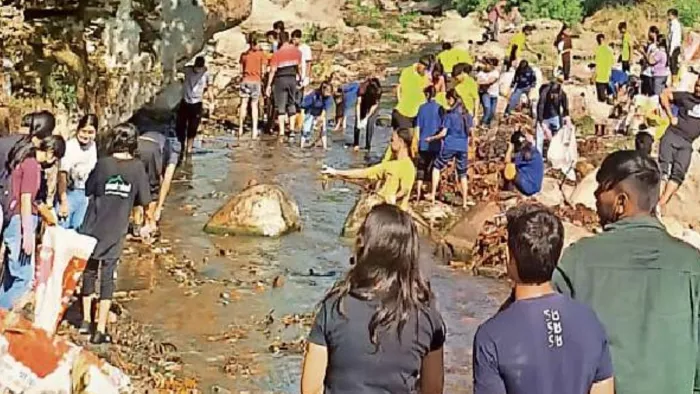 टपकेश्वर महादेव मंदिर परिसर में तमसा नदी की सफाई करते मैड संस्था व अन्य संगठनों से जुड़े लोग l जागरण