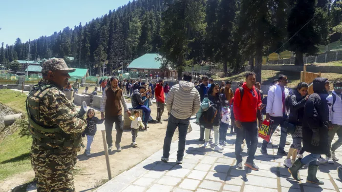 गुलमर्ग: जम्मू-कश्मीर के गुलमर्ग में पर्यटकों के पहुंचने पर सुरक्षाकर्मी पहरा देते हुए (पीटीआई फोटो)