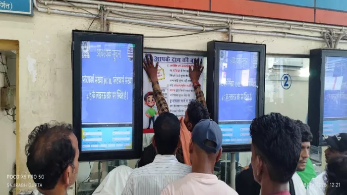 कैंट स्टेशन स्थित यात्री आश्रय हाल में जागरूकता संदेश लिखा स्टीकर लगाता कर्मचारी। जागरण
