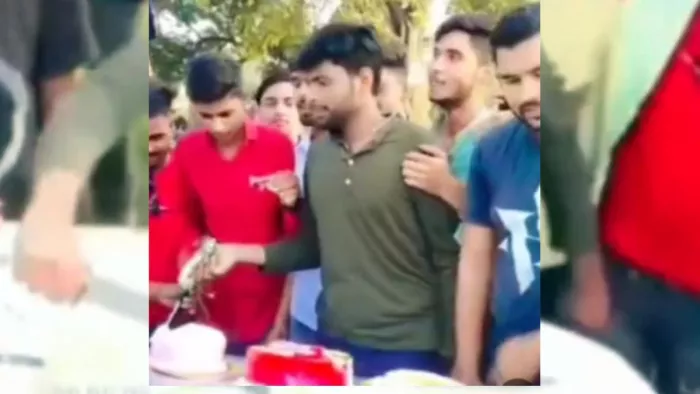 UP News: कार की बाेनट पर तलवार से केक काटता युवक। (वीडियो की तस्वीर।)