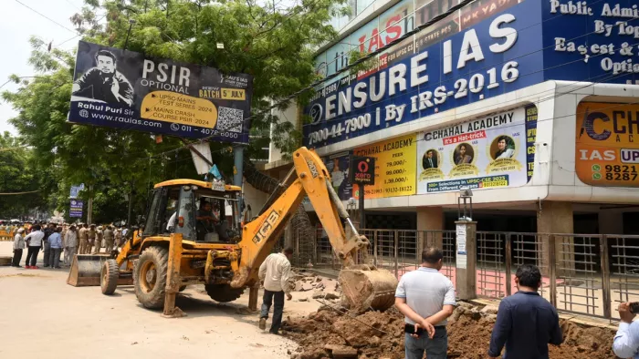 ओल्ड राजेंद्र नगर स्थित सतपाल भटिया मार्ग के कोचिंग सेंटर के रैंप को तोड़ता बुल्डोजर।