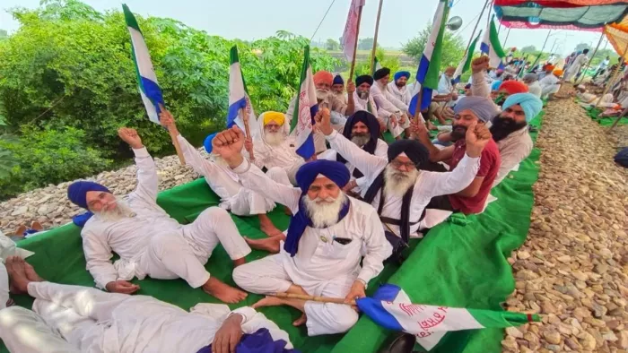 अपनी मांगों को लेकर रेलवे ट्रैक पर धरना प्रदर्शन करते किसान।