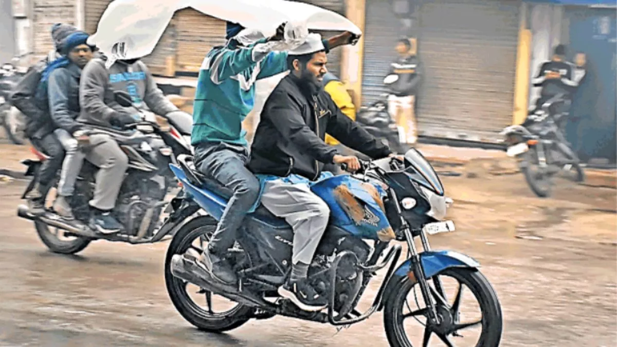 बूंदाबांदी के दौरान जीटी रोड से गुजरते बाइक सवार।