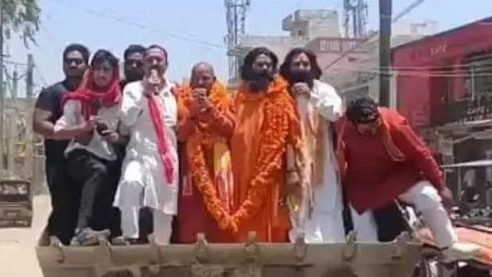 बुलडोजर पर सवार होकर नामांकन को जाते अखिलेश्वर श्रीवैष्णव।