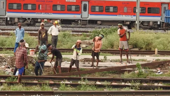 रेलवे स्टेशन पर रेल पटरियों की मरम्मत करते मजदूर। जागरण