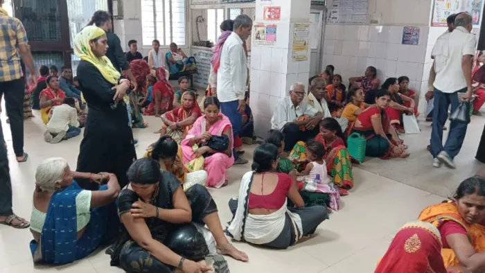 नीचे बैठकर अपनी बारी का इंतजार करते मरीज