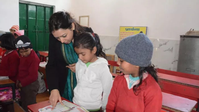 खेड़की प्राथमिक विद्यालय में निरीक्षण के दौरान छात्राओं से किताब पढ़वा कर देखतीं डीएम अस्मिता लाल। सौ. सूचना विभाग