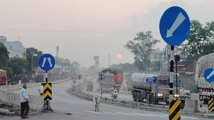 शाम में आसमान में छाये बादल और हाईवे पर चलते भारी वाहन