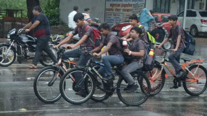 आगरा में तेज बारिश में भीगकर जाते बच्चे। जागरण