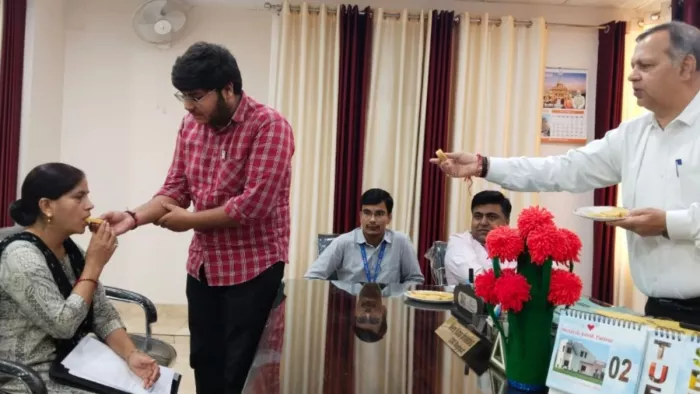 विकास भवन में मृतक आश्रित में बेटे के ग्राम विकास अधिकारी बनने पर मां को मिठाई खिलाता बेटा। जागरण