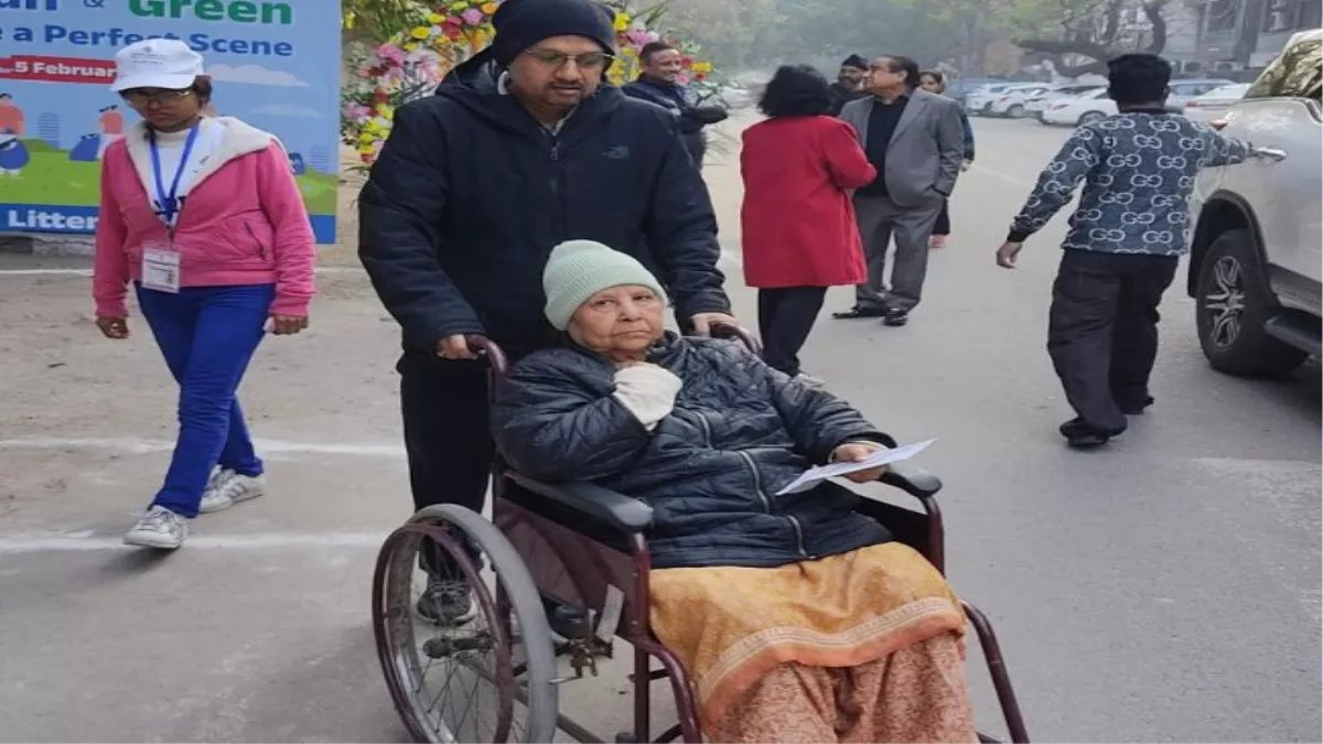 व्हीलचेयर पर मतदान करने पहुंची बुजुर्ग महिला